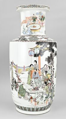 un grand vase avec un tableau posé sur une table