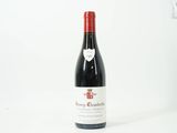 une bouteille de vin rouge posée sur une table blanche