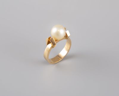 une bague en or sertie d'une perle et d'un diamant