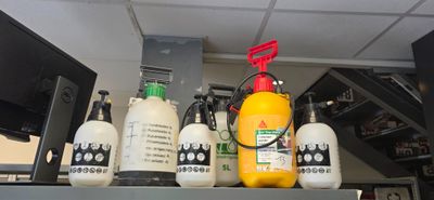 de nombreuses bouteilles de liquide posées sur une étagère dans une pièce