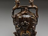 un vase marron surmonté de deux oiseaux