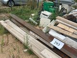 un tas de bois posé dans un jardin, près d'une clôture
