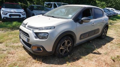 La voiture est garée dans l'herbe, à côté d'autres voitures.