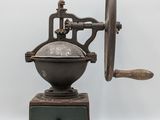 an old coffee grinder on a wooden stand with a white background