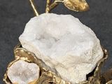 a gold cup with a rock and a flower on it
