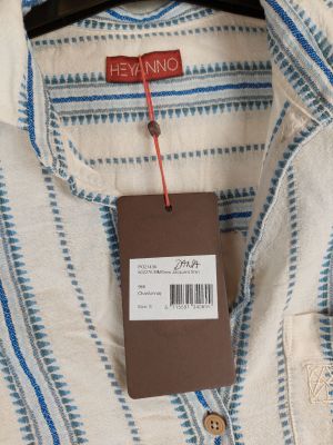 a close up of a blue and white striped shirt with a tag on it