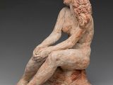 an image of a statue of a woman sitting on a rock