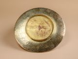 a silver plate with a picture of a woman on it