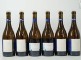 six bottles of wine are lined up in a row on a white surface
