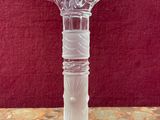 a glass vase on a table with a red background