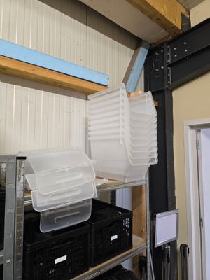 une pile de récipients en plastique posée sur une étagère dans un garage