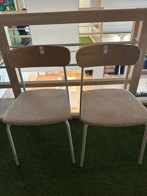 pair of chairs in front of a window with grass on the ground