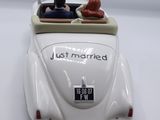 a figurine of a bride and groom in a wedding car