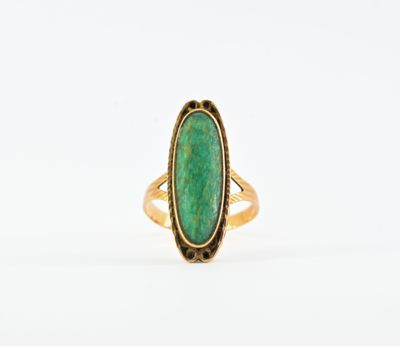 une bague en or avec une pierre verte au centre