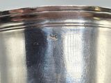 a silver pot with a handle on a table