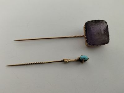 a pair of earrings with a purple stone and a turquoise bead