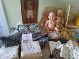 a bed with a bunch of dolls and other items on it