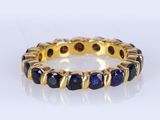 un gros plan sur une bague en or sertie de saphirs bleus