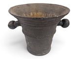 un vieux vase posé sur une surface blanche
