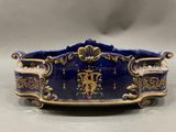a close up of a blue and gold bowl on a table