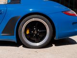 a blue sports car parked in front of a brick building