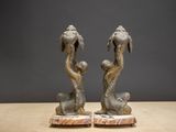 two statues of a man and a woman sitting on a table