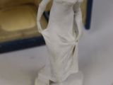 a white statue of a woman in a dress in front of a box