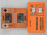 une console Nintendo orange posée sur une table blanche