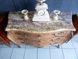 a marble clock on top of a chest of drawers