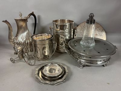 un service à thé en argent posé sur une table, à côté d'autres objets en argent