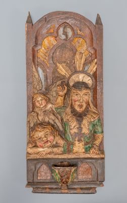 une vieille sculpture en bois représentant un homme tenant un bébé et un oiseau