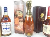 Plusieurs bouteilles de différentes sortes d'alcool sont alignées sur une table