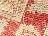a close up of a red and beige area rug with many different colors