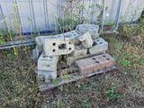 a pile of bricks sitting on the ground in front of a fence