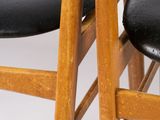 two black chairs sitting next to each other on a white surface