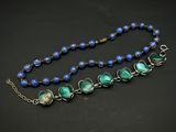 un gros plan sur un collier composé de perles bleues et vertes