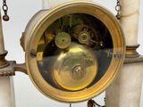 a clock that is hanging on a pole with chains