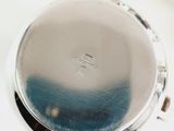 a close up of a silver watch on a white surface