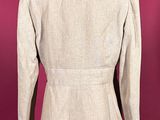 an image of a woman ' s beige jacket on a mannequin stand