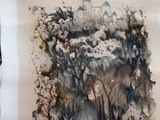 une personne tenant un morceau de papier sur lequel est représentée une peinture