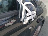a black car with a white bag on the side of it