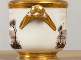 a white and gold vase with a bird on it