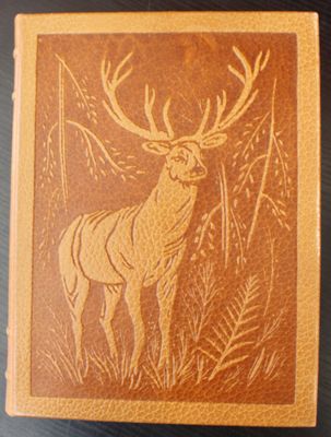 an old book with a deer on it sitting on a table