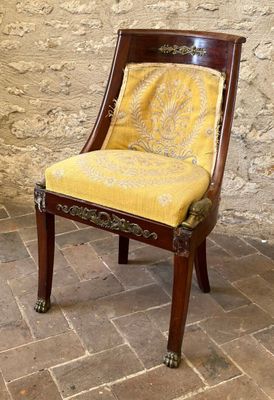 a chair with a yellow upholstered seat in front of a brick wall