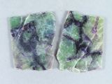 deux morceaux de marbre vert et violet posés sur une surface blanche