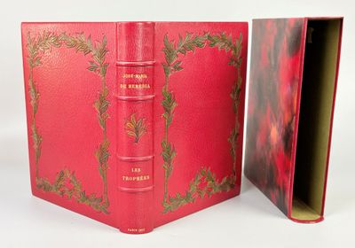 un livre rouge ouvert sur une surface blanche