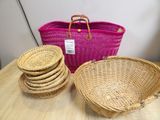 several wicker baskets are stacked on a table with a pink bag