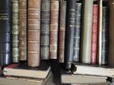 many old books that are stacked on a shelf