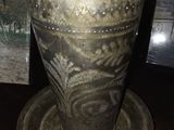 un vase en argent posé sur une table à côté d'un tableau représentant un cheval