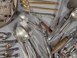 a lot of silver spoons and spoons on the table